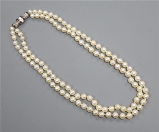 A double-row cultured pearl choker necklace with diamond and ruby-set white metal clasp, 39cm.